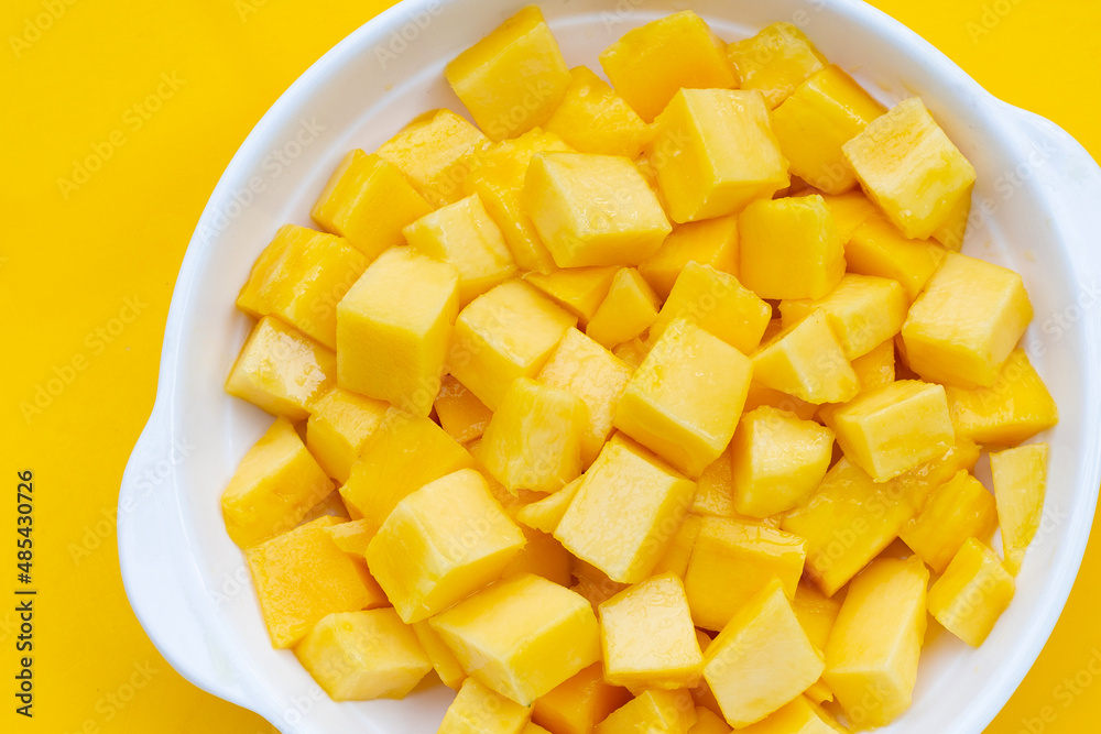 Tropical fruit, Mango cube slices in white bowl on yellow background. Tropical fruit, Mango cube slices in white bowl on yellow background.