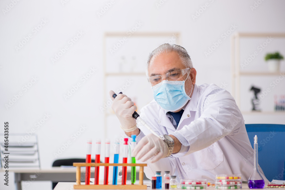 Old male chemist in drug synthesis concept Old male chemist in drug synthesis concept