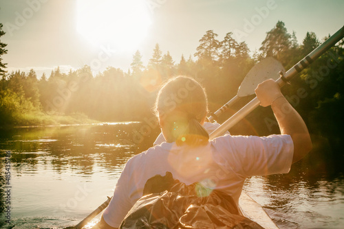 On kayak on river rowing two girls bright sun photo