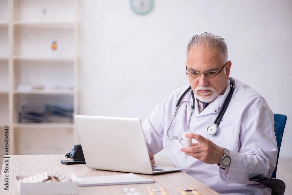Old male doctor working at the hospital Old male doctor working at the hospital
