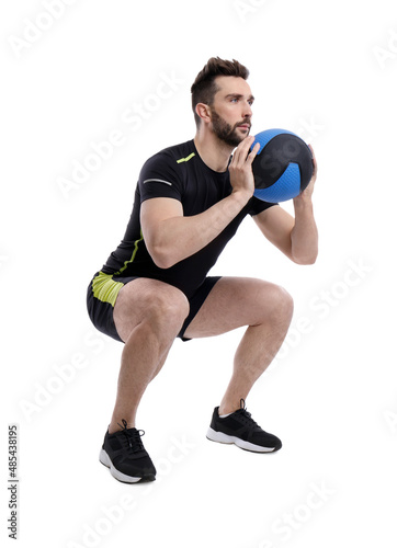 Athletic man doing squats with medicine ball isolated on white © New Africa