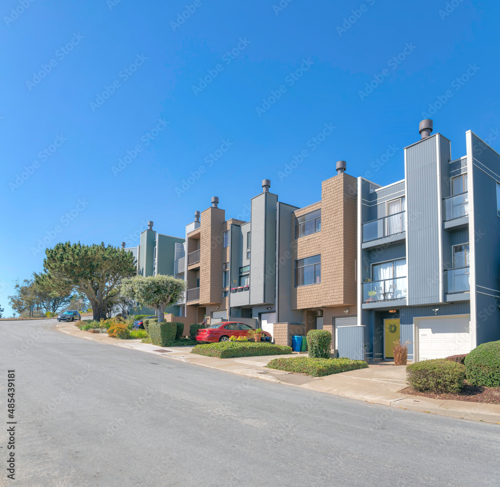 Modern townhouses exterior with brown shingles and gray wood sidings Modern townhouses exterior with brown shingles and gray wood sidings