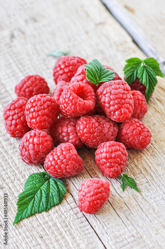 Heap of fresh ripe raspberries on a wooden background. Close up.