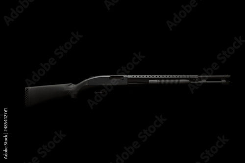 Pump-action 12 gauge shotgun isolated on a white back. Close-up shot of part of a shotgun. A smooth-bore weapon with a plastic stock.