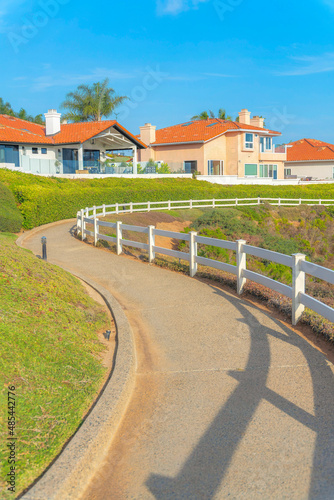 Curved concrete pathway along with the landscaped shrubs on the side at Southern California © Jason
