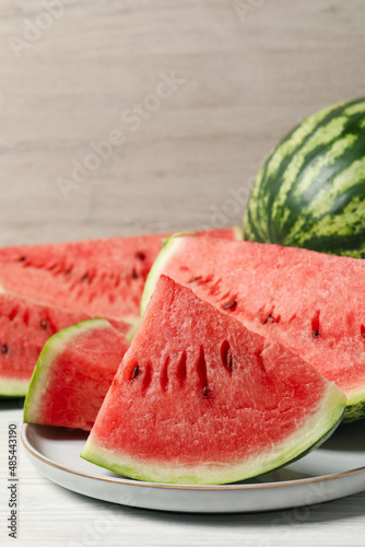 Tasty ripe watermelons on white wooden table