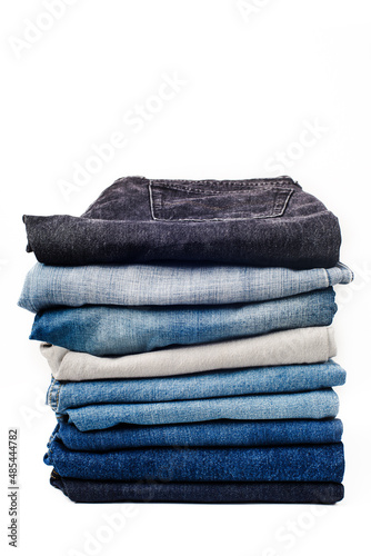 stack of different jeans on a white background.