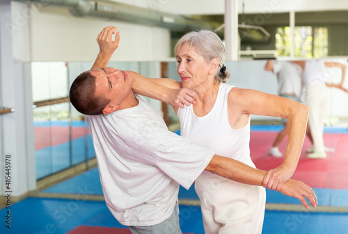 Mature woman self defense training gym learning to do painful grip