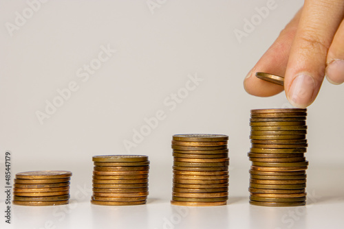 Female hand placing coin on stacks