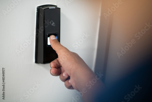 Man pressing fingerprint scanner on alarm system indoorsFinger print scan for unlock door security system