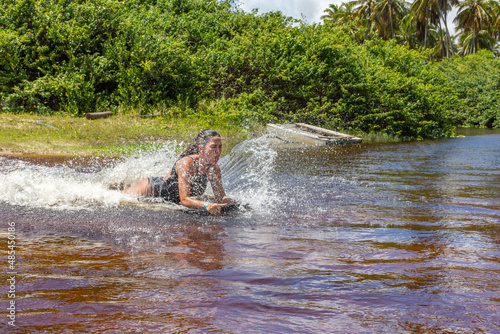 Mulher deslizando numa prancha sob agua num rio