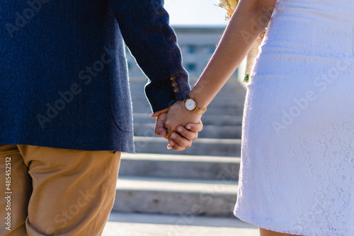 two newlyweds holding hands, close up, unrecognizable people