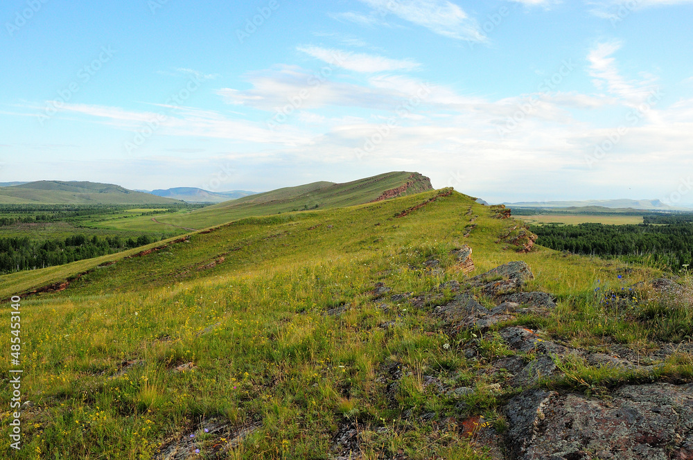 Stone formations on top of high hills in the endless summer steppe.