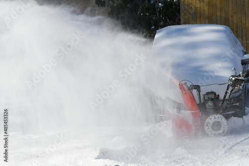 removing snow on the driveway of the house by snow blower © nd700