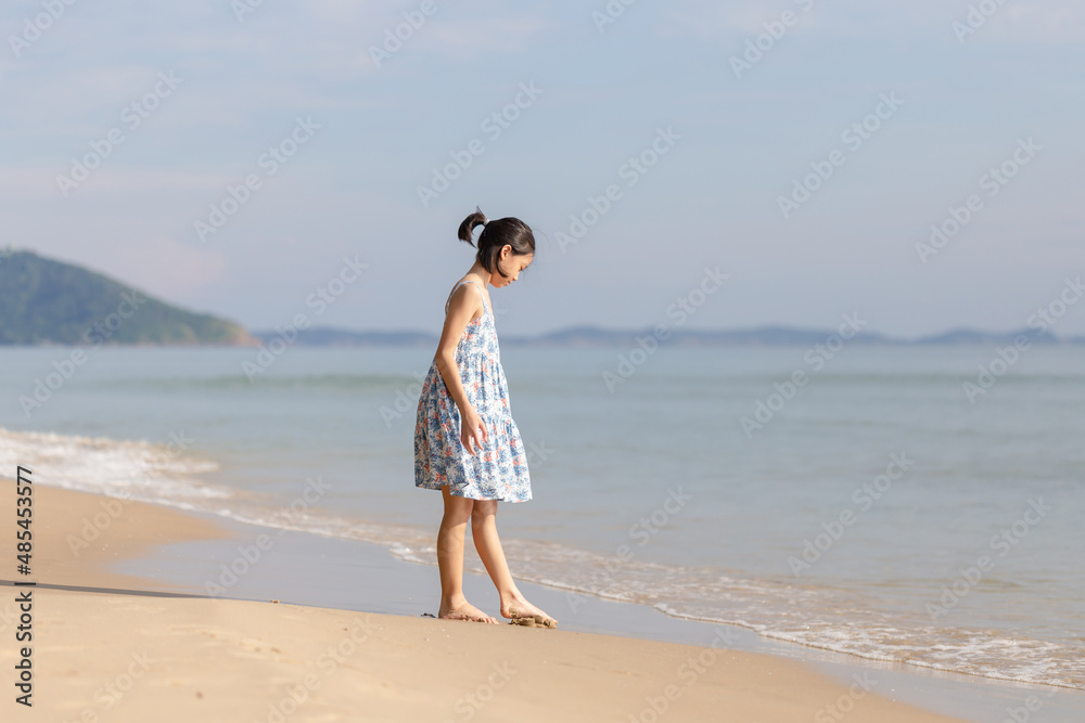 Enjoying little girl playing on the beach, Kid relaxing outdoor Enjoying little girl playing on the beach, Kid relaxing outdoor