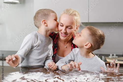 Принти на полотні A young mother and two sons cook in a large and bright kitchen