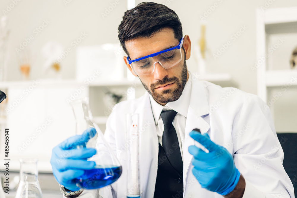 Professional scientist man research and working doing a vaccine while making analyzing for coronavirus vaccine mixing liquid in test tube with inscription Covid-19.Man looking sample coronavirus Professional scientist man research and working doing a vaccine while making analyzing for coronavirus vaccine mixing liquid in test tube with inscription Covid-19.Man looking sample coronavirus