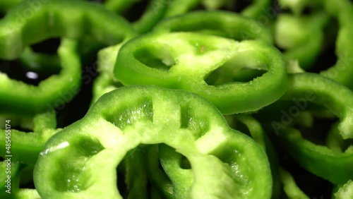 Sliced green bell peppers rotation background.