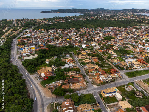 Amazing seaside town amidst nature and mountains top view with the sea in the background, drone, Armação de Búzios, Rio de Janeiro, Brazil