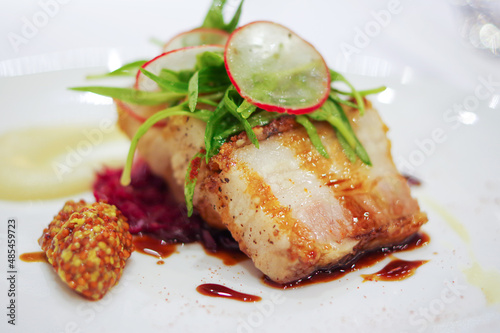 Fototapeta chinese crispy roasted pork belly with sauce and sliced radish on white plate