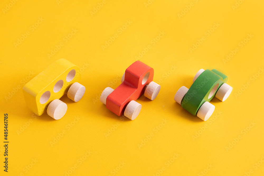 Wooden toy car in cartoon style on yellow background. Colorful and Transportation background, eco kid toys Montessori . 