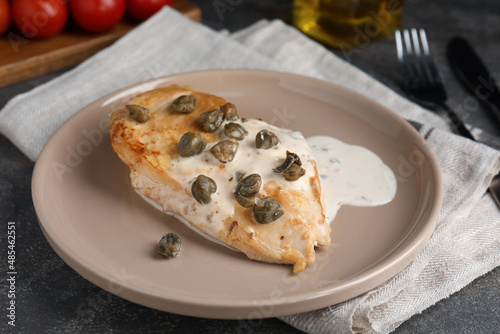 Delicious chicken fillet with capers and sauce served on grey table, closeup