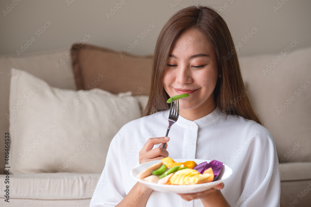 Portrait image of a young woman eating vegetables, Vegan, clean food, dieting concept Portrait image of a young woman eating vegetables, Vegan, clean food, dieting concept