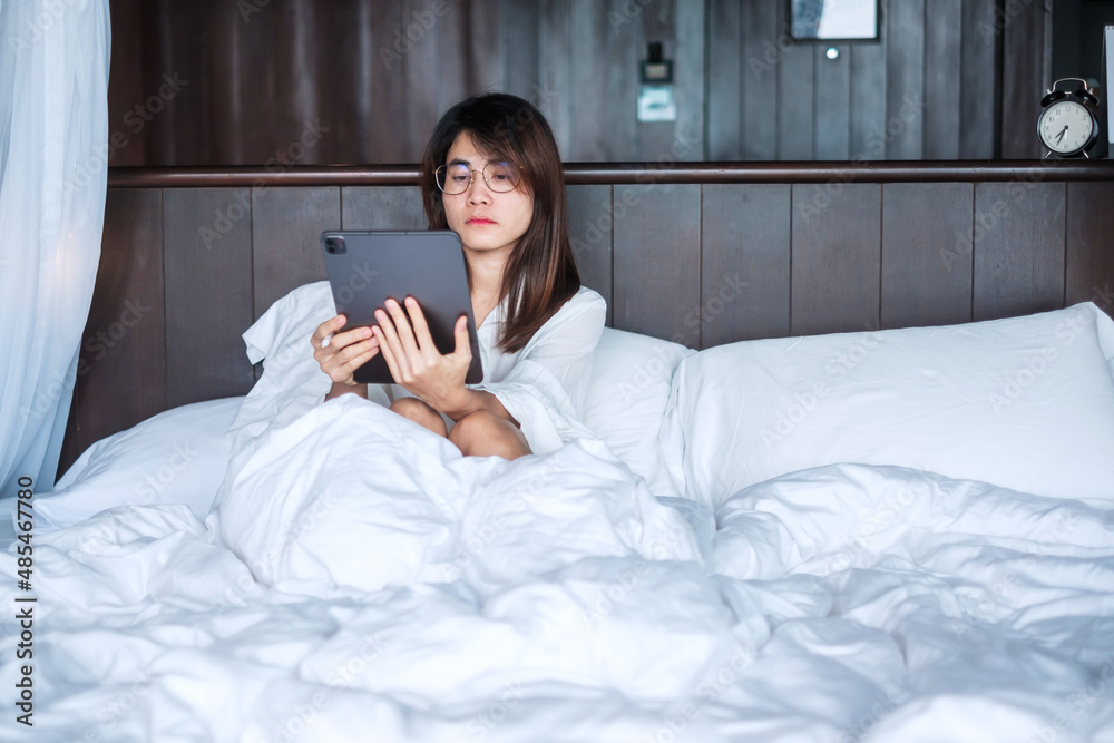 Happy woman using tablet for social media, young female watching movies on computer pad on bed at home. technology, network, online shopping, e commerce, lifestyle and digital communication concept Happy woman using tablet for social media, young female watching movies on computer pad on bed at home. technology, network, online shopping, e commerce, lifestyle and digital communication concept