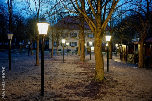 Bäume und Lampen zur blauen Stunde im Biergarten