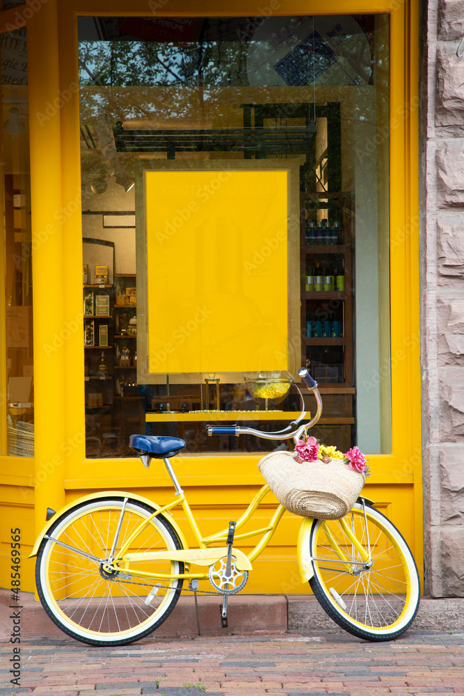 Yellow storefront with a yellow bike parked in front of a yellow sign