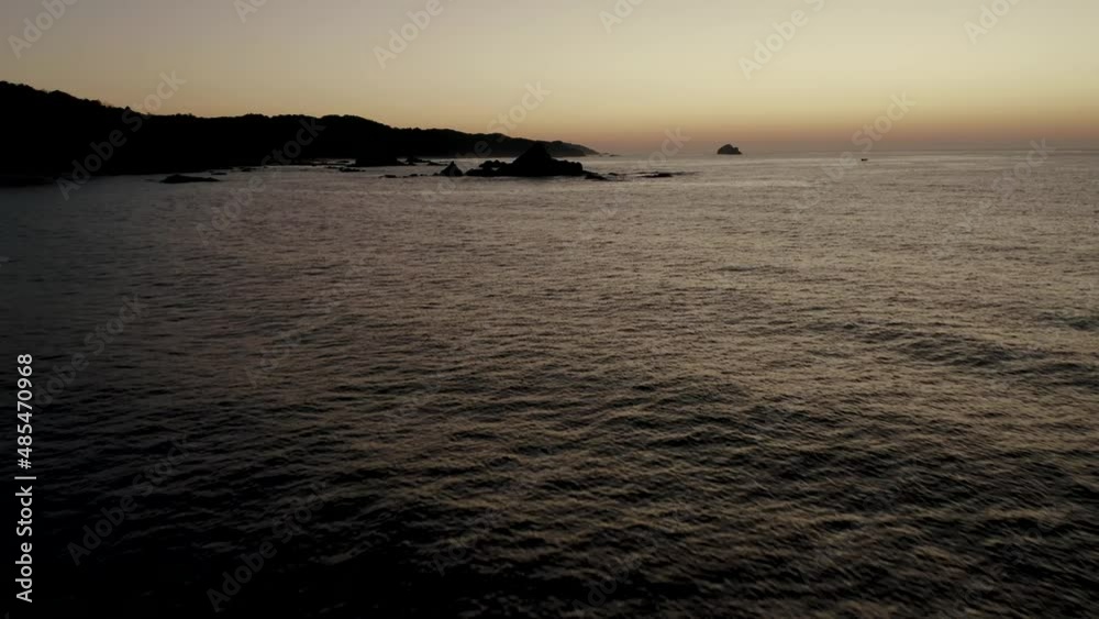 Aerial backwards shot of rocky coastline and Pacific Ocean coast of Oaxaca after sunset Aerial backwards shot of rocky coastline and Pacific Ocean coast of Oaxaca after sunset