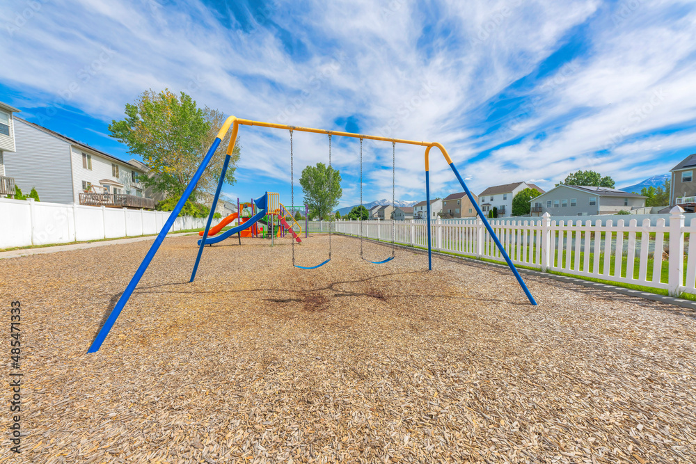 Community playground with white picket fence in a residential area at Utah Valley Community playground with white picket fence in a residential area at Utah Valley