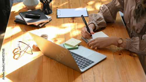 Photography Cropped shot of a businesswoman taking a notes on memo pad.
