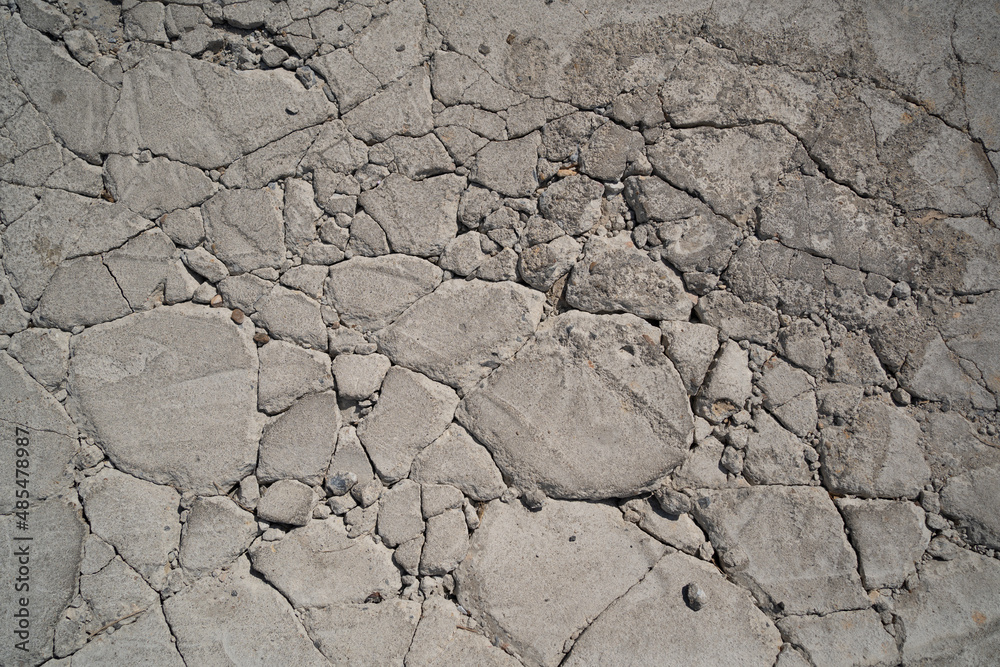 Gray concrete floor cracked into random-sized rocks texture background Gray concrete floor cracked into random-sized rocks texture background