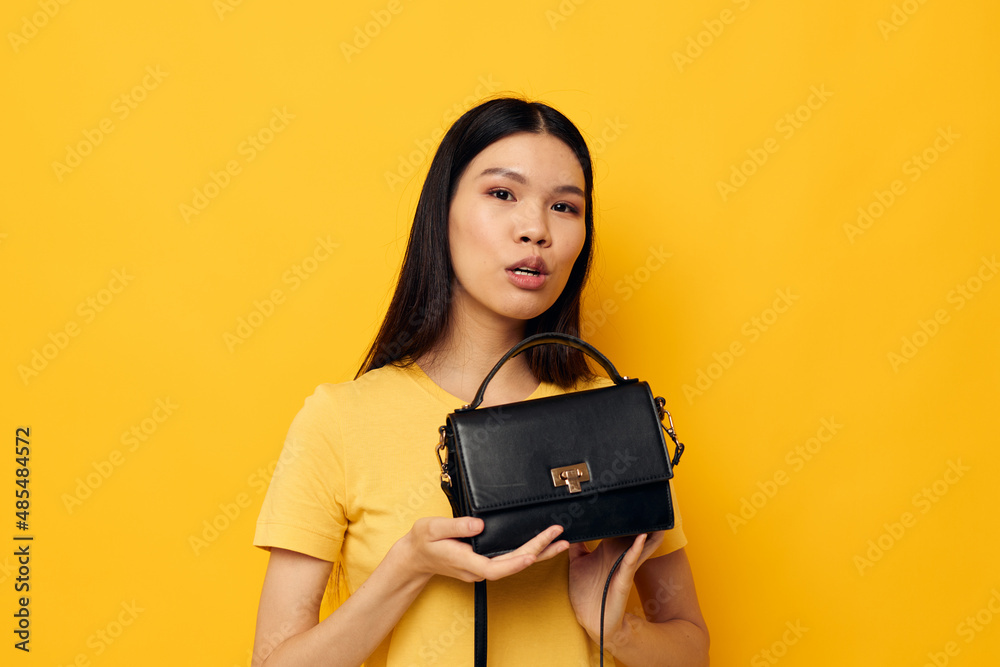 cheerful woman in a yellow t-shirt black womens bag cheerful woman in a yellow t-shirt black womens bag