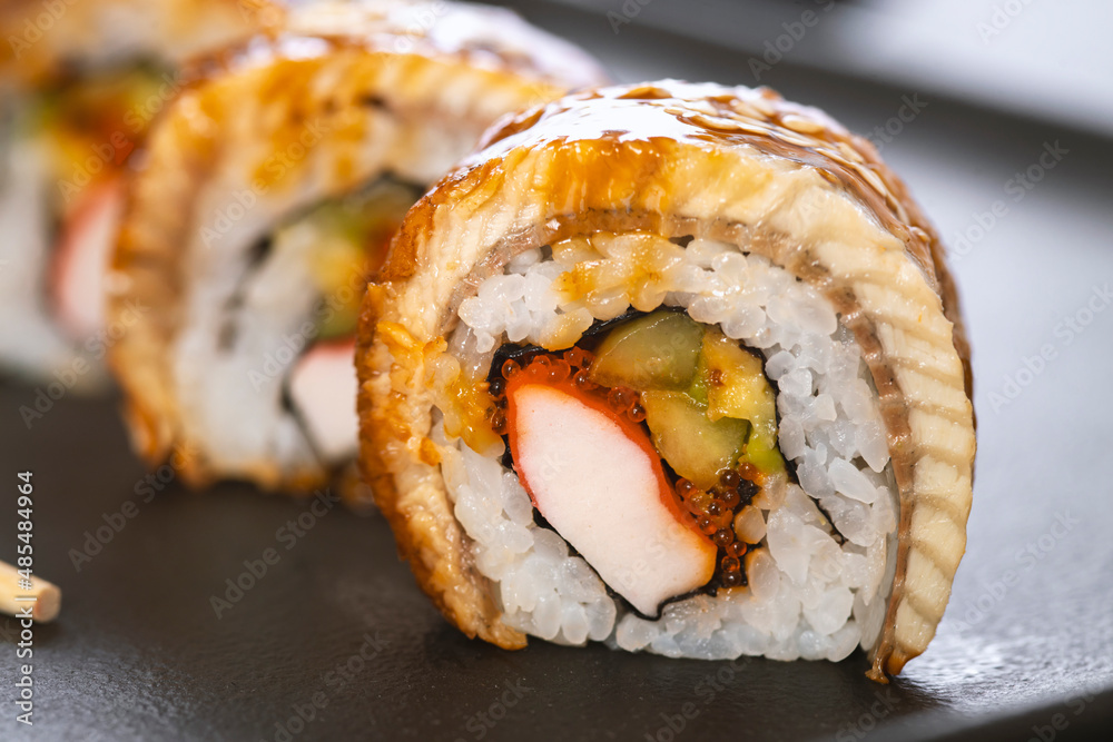 Sushi roll with rice, crab, cucumber, avocado ,tobiko, eel. Sushi menu. Japanese food.