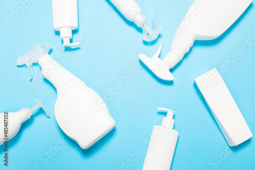 white bottles of cleaning agent on a blue background on the side. Professional cleaning products, general cleaning. Household chemicals top view