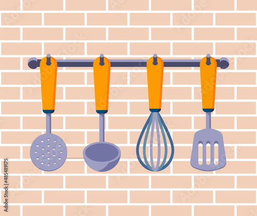 Hanging kitchen utensils on a brick wall: ladle, whisk, slotted spoon, spatula. Kitchen or restaurant interior in flat design. Vector stock illustration.