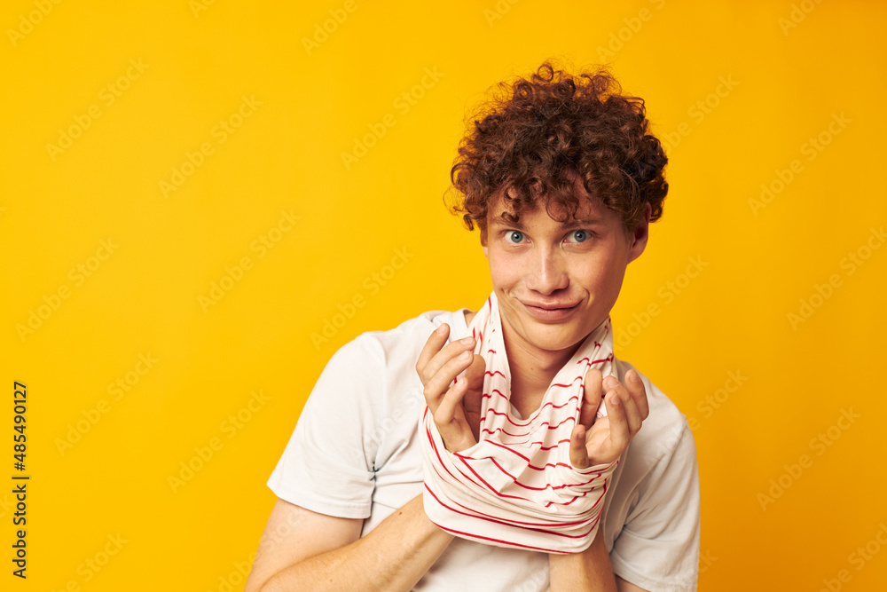 portrait of a young curly man in a white t-shirt holds a striped t-shirt fashion youth style Lifestyle unaltered portrait of a young curly man in a white t-shirt holds a striped t-shirt fashion youth style Lifestyle unaltered