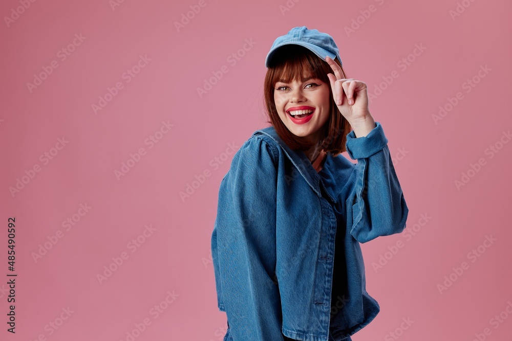 Positive young woman denim clothing fashion posing cap color background unaltered Positive young woman denim clothing fashion posing cap color background unaltered