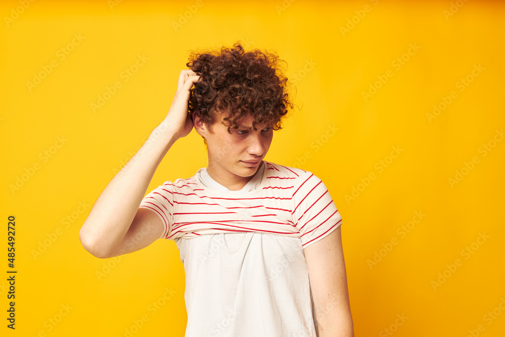 cute red-haired guy putting on a striped t-shirt posing isolated background unaltered cute red-haired guy putting on a striped t-shirt posing isolated background unaltered