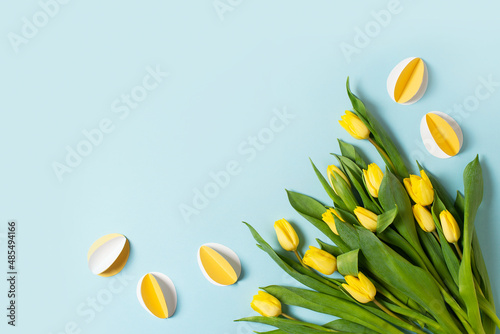 Yellow paper crafting eggs on blue background, easter and spring concept