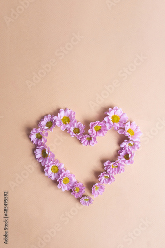 Beautiful light purple flower heart on light yellow background copy space valentine s day spring concept