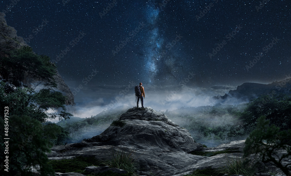 Wanderer auf einem Berg schaut in den Sternenhimmel