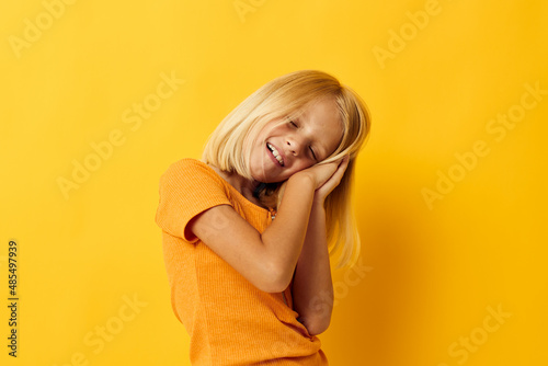 kid girl in a yellow t-shirt smile posing studio color background unaltered