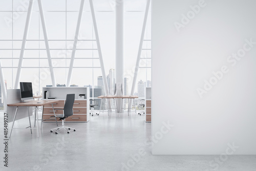 Blank white wall in the foreground of modern spacious office with wooden detailed workspaces, modern computers and city view from huge windows. 3D rendering, mock up