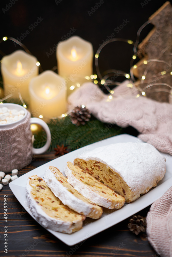 Sliced Traditional Christmas stollen cake with marzipan and New Year decorations on wooden background Sliced Traditional Christmas stollen cake with marzipan and New Year decorations on wooden background