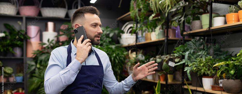 flower warehouse worker at a garden center answering a phone call