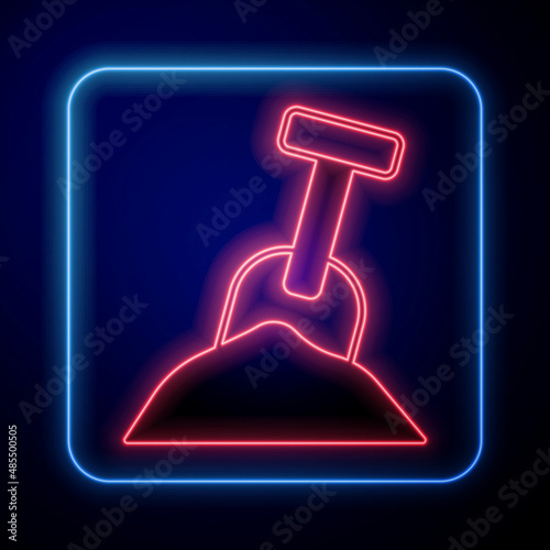 Glowing neon Sandbox with sand and shovel icon isolated on black background. Vector