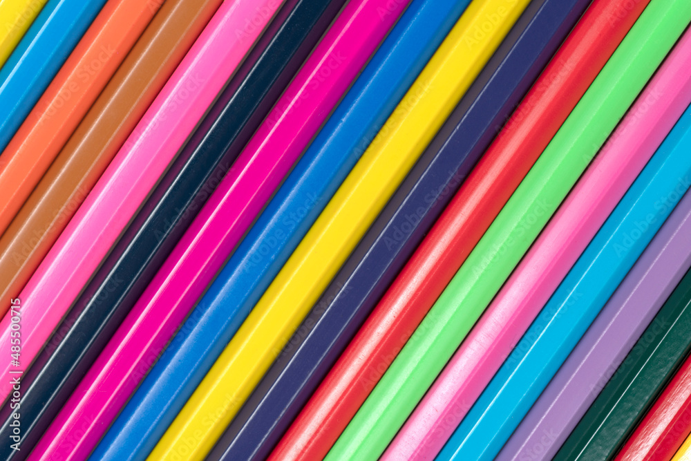 Wooden colored pencils background textured. A line of multicolored pencils in a large plan Wooden colored pencils background textured. A line of multicolored pencils in a large plan